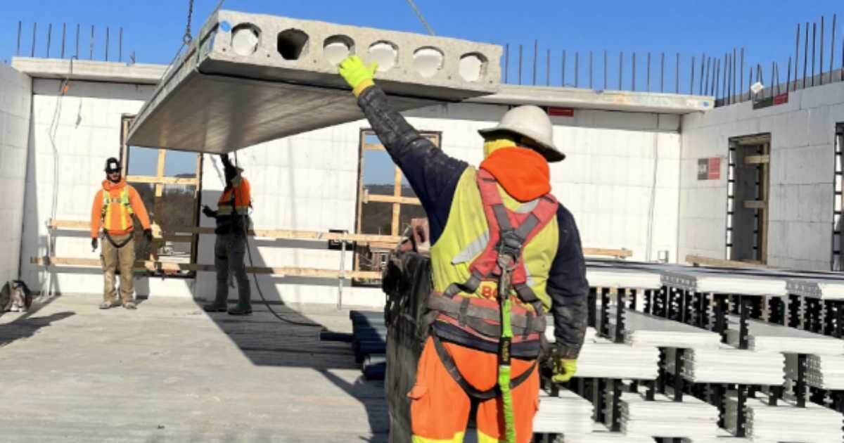 large concrete slab being places by Crain and construction workers 